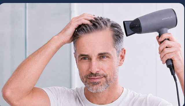 Man drying his hair with a hair dryer